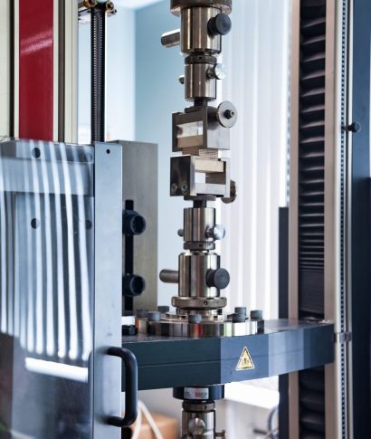 A specialized piece of equipment is set up inside a scientific laboratory to conduct material tests.